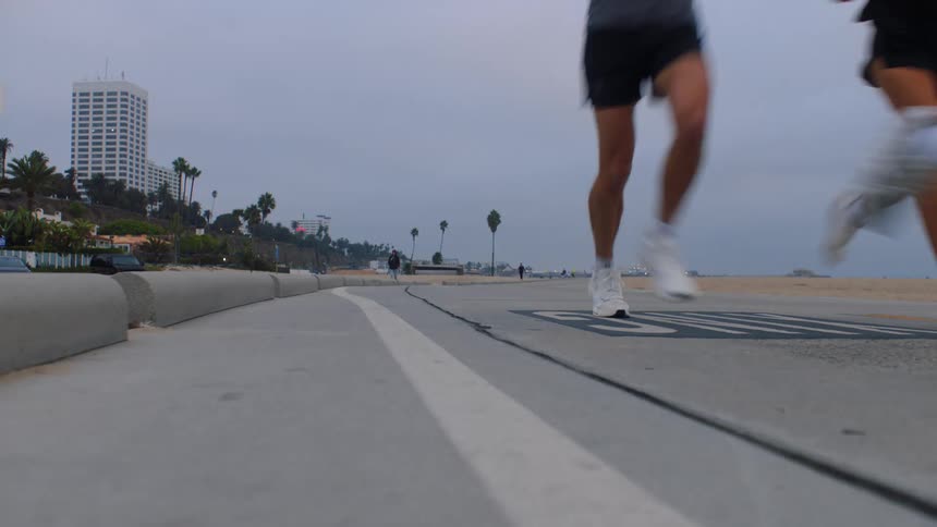A small group of young adults jogging outdoors during a fitness session in daytime