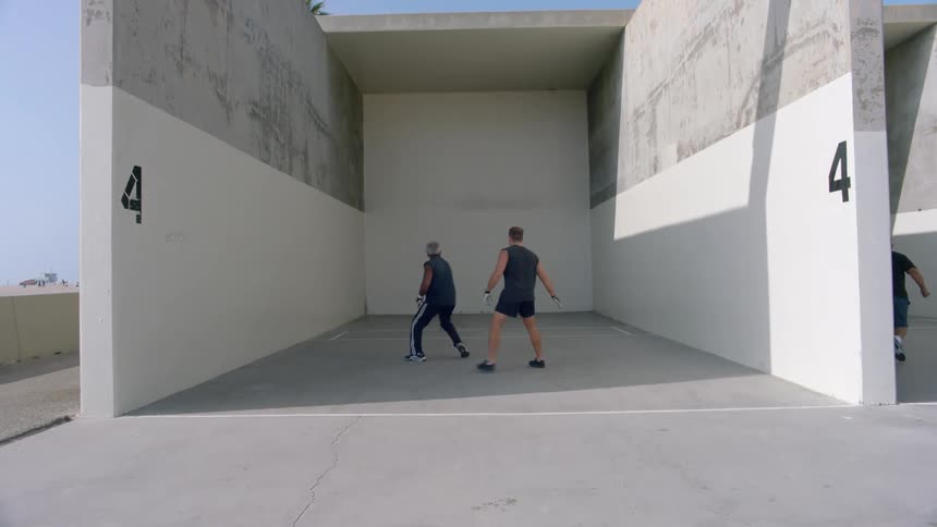 Two people playing hand ball outdoors