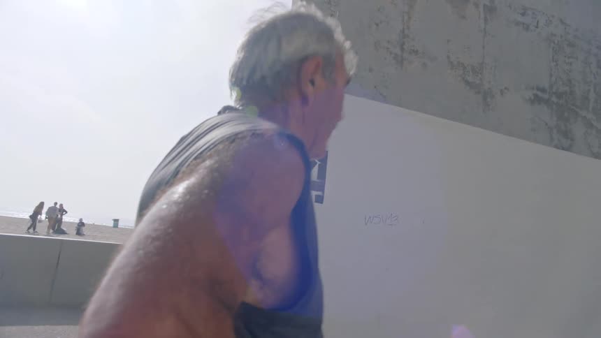 A middle aged man standing outdoors after a sparring session during daytime