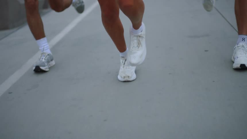 Legs of three people wearing white shoes running
