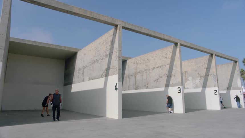 Group of men on a handball court on a sunny day playing in pairs