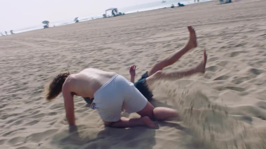 Some people playing football on the beach