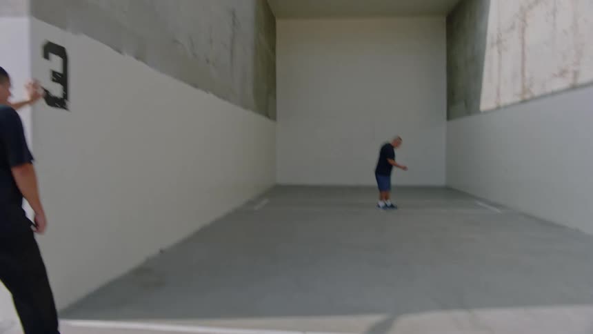 Three men in an outdoor area practicing sports with a small ball