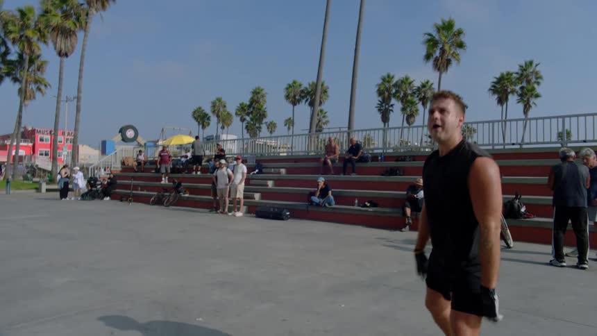 A man hits a ball while playing outdoor handball on a public court