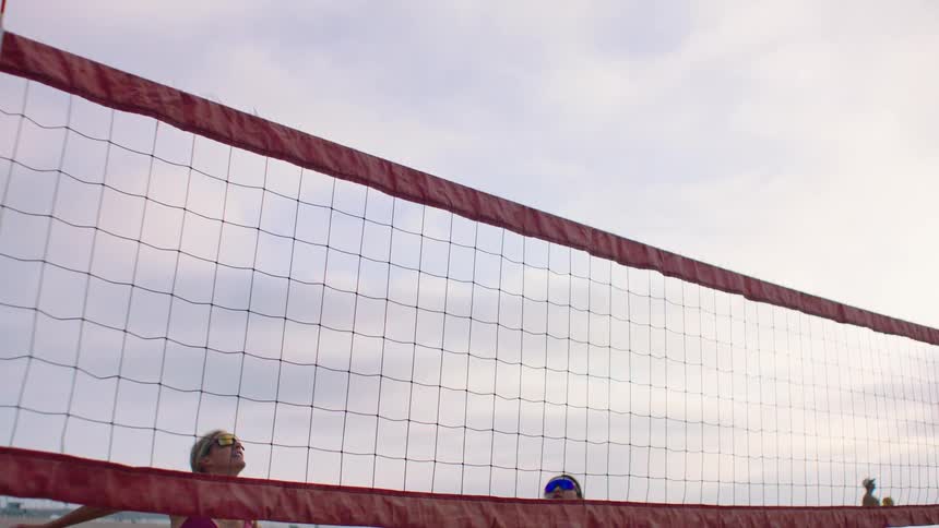 Pair playing beach volleyball outdoors