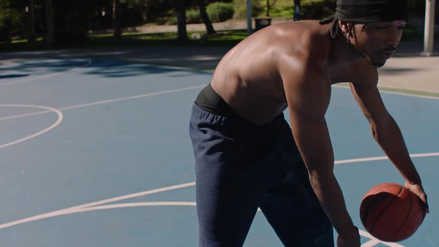 A man playing basketball outdoors