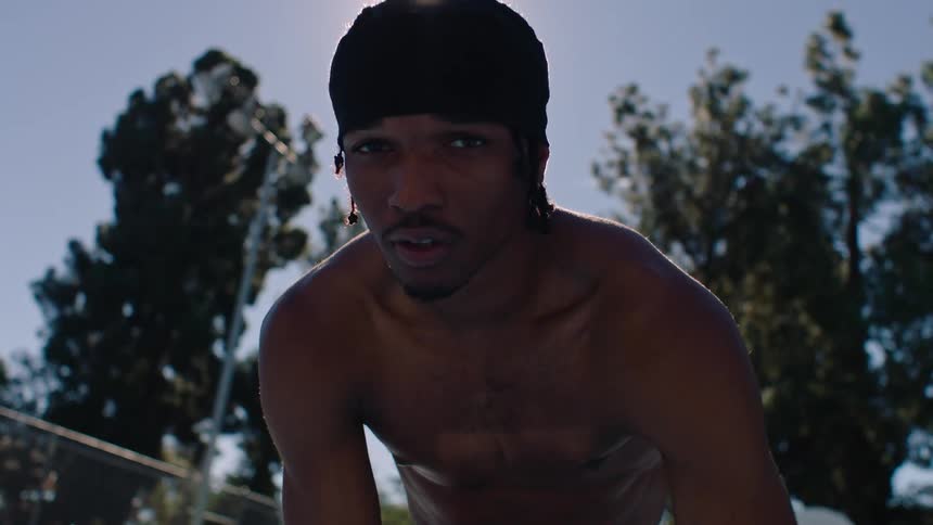 Close up portrait of a young black male athlete playing basketball at an outdoor court during daytime
