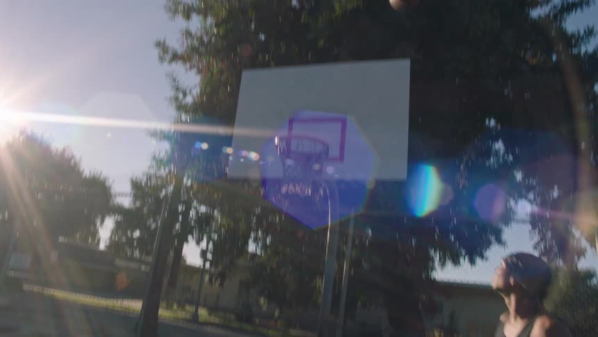 Two men playing basketball on an outdoor court