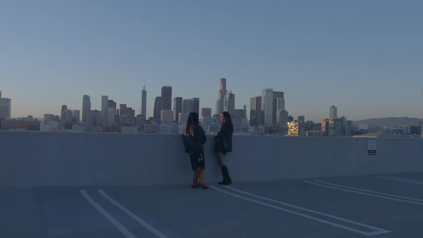 Two women talking in an outdoor parking lot