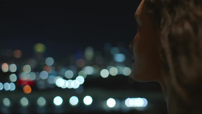Woman gazing at the horizon at night