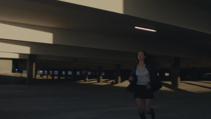Woman runs and leans on a balcony overlooking urban buildings