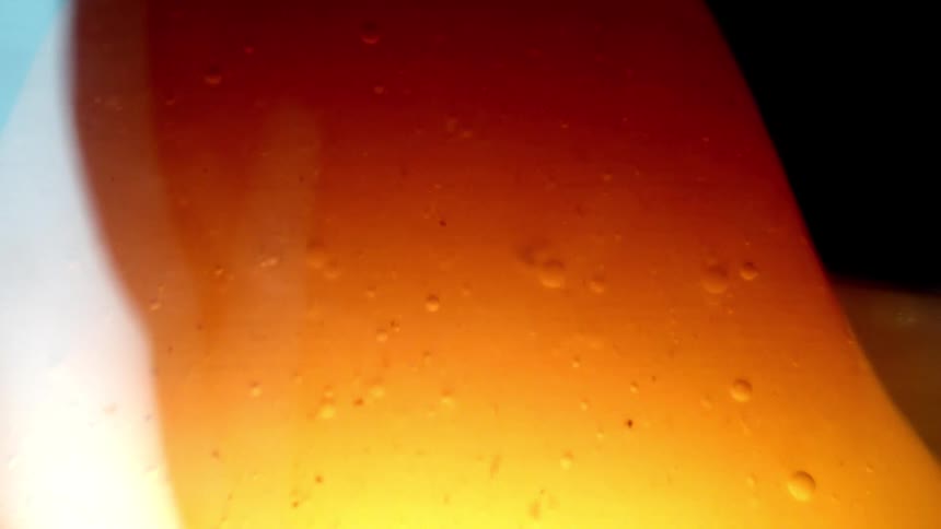 Translucent orange liquid with small suspended bubbles and a light gradient