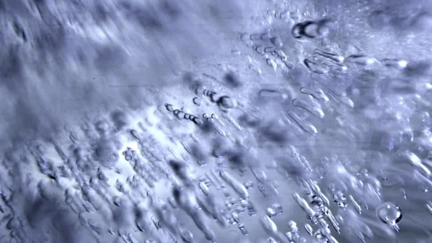 Water drips off ice outdoor at midday