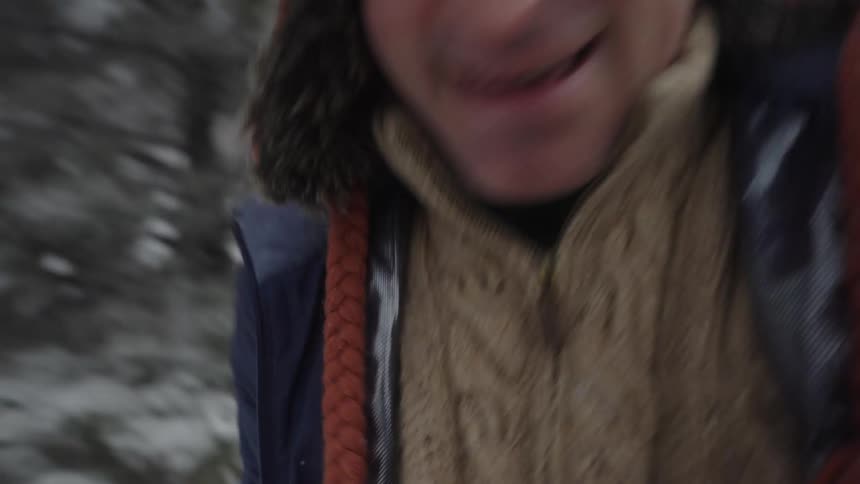 Man standing in a field surrounded by snow covered trees