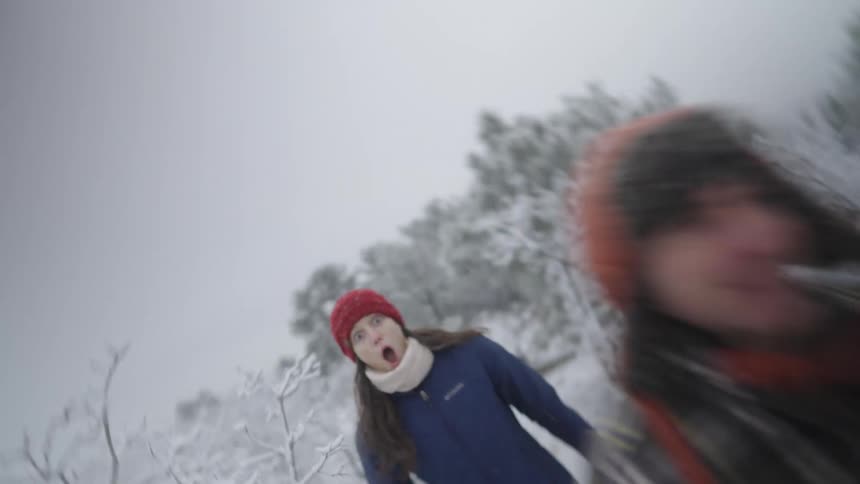 Two people walking along a snowcovered trail in a natural environment during winter
