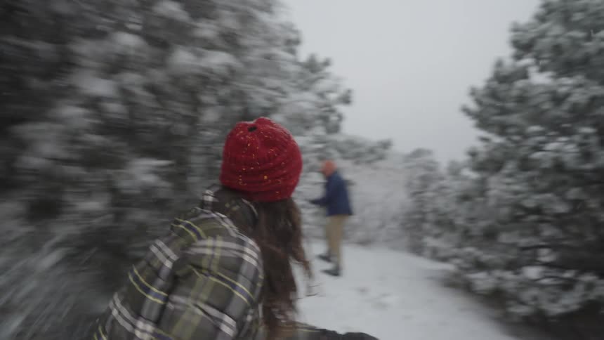 A man and woman having a snowball fight