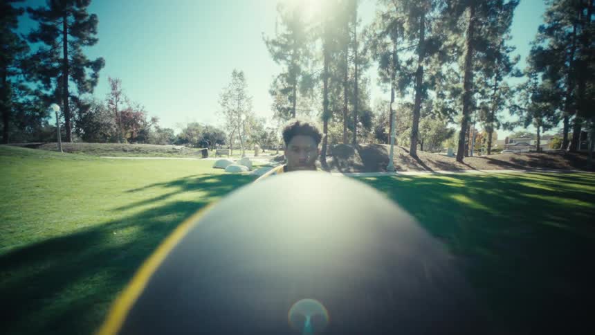 Young man catching a ball midair in a park at midday sunlight highlighting the motion