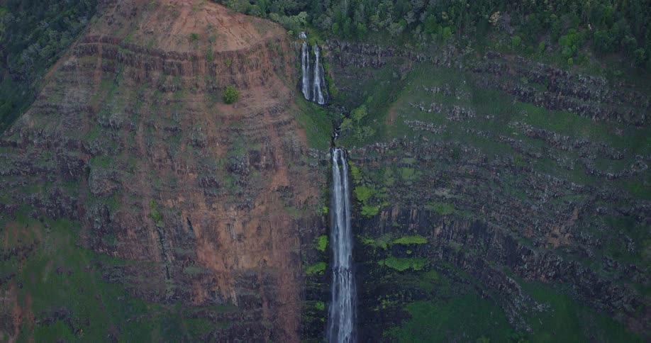 A waterfall cascades down the sheer side of a very tall cliff