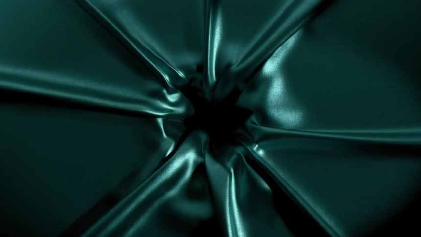 Smooth blue fabric falls forming a dark opening at its center