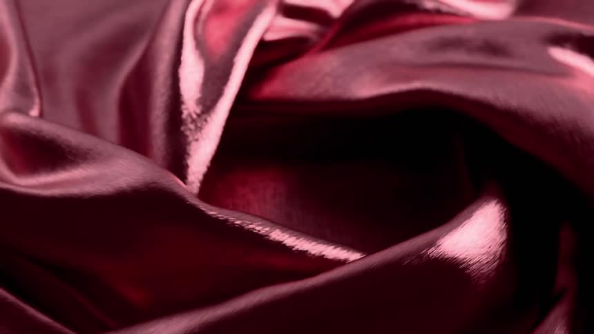 A piece of shiny fabric is twisted and twirled around repeatedly