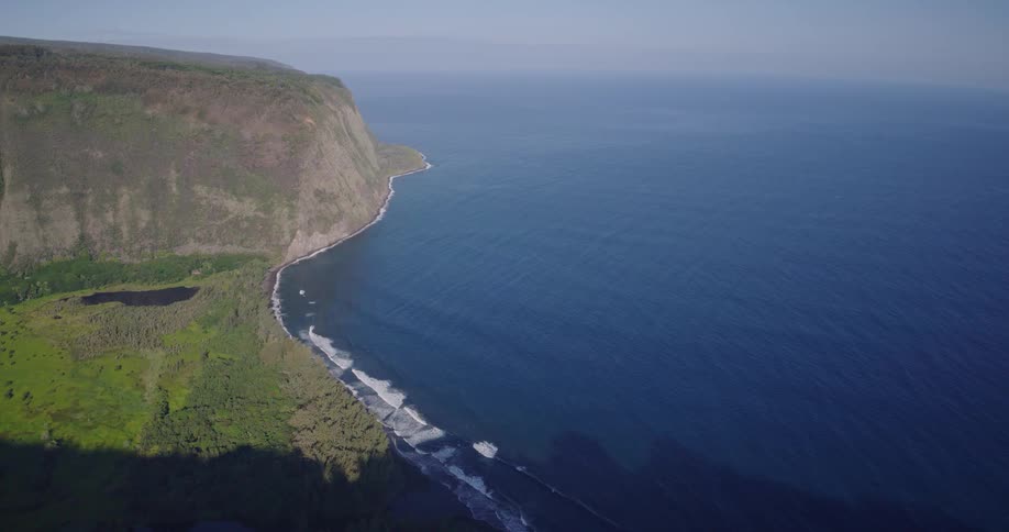 Waves roll in to shore and splash against the promontory