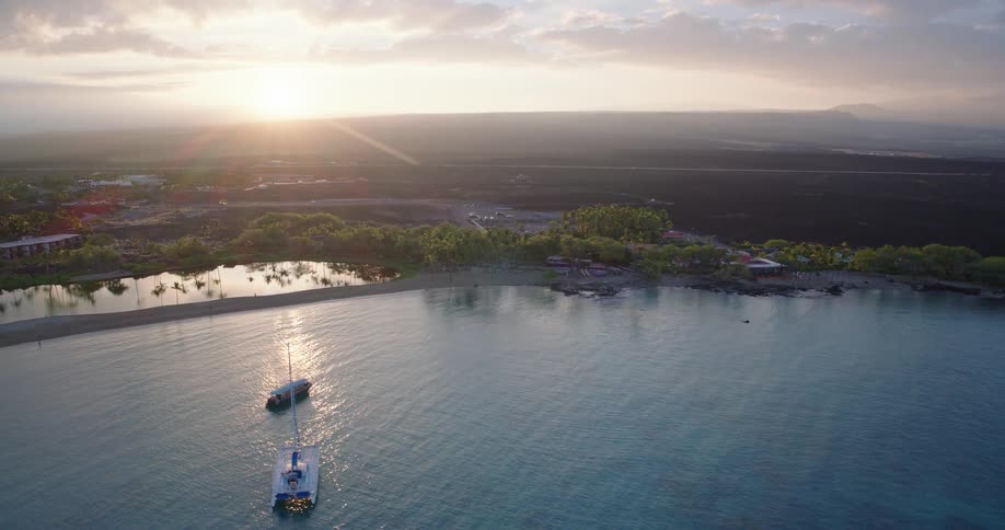 Aerial view of a calm tropical beach with palm lined lagoons and a narrow shore by a coastal resort