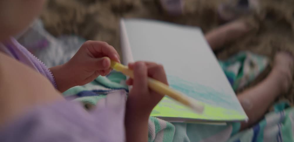 Girl sitting on a blanket on a summer day with a drawing pad gestures