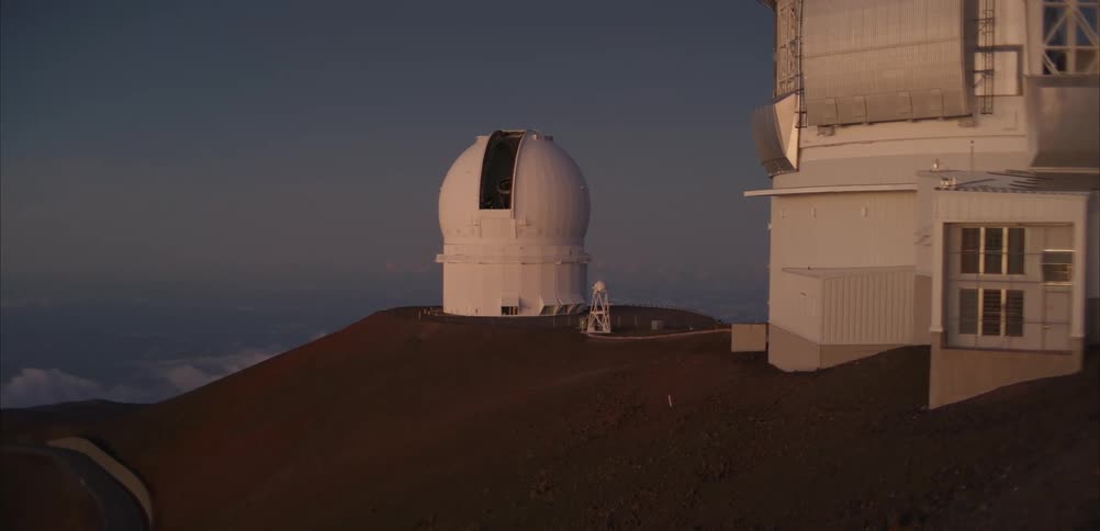 Observatory domes rise on rocky summit under clear sky poised to explore the cosmos