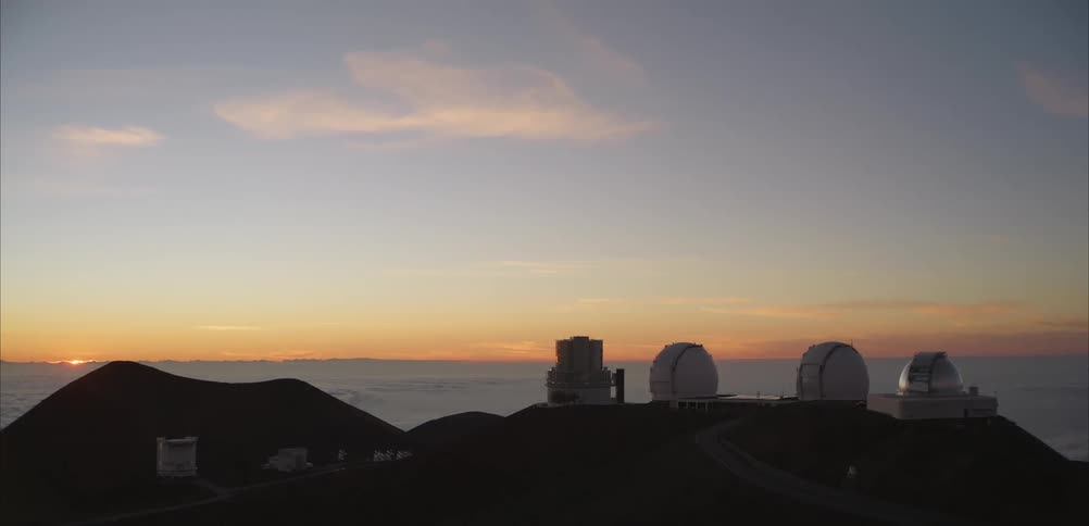 Group of observatories on a mountain ridge above the clouds during sunset