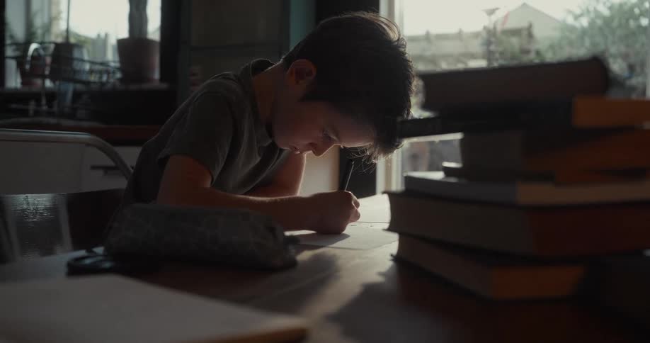 A child writing on paper with a pen