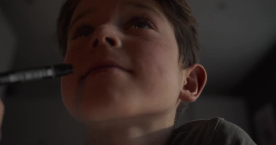 A child while indoor puts a pen in his mouth
