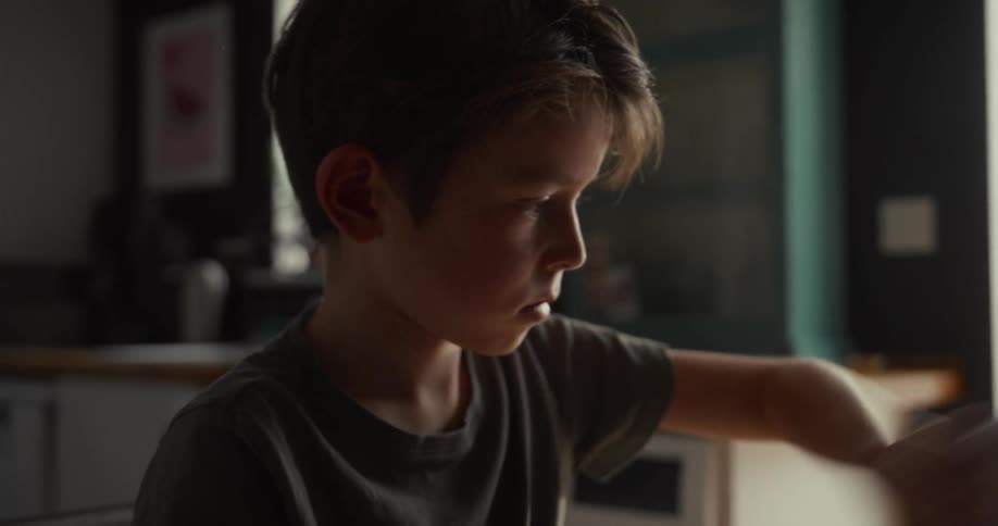 A child sitting in a room ripping papers out of a book