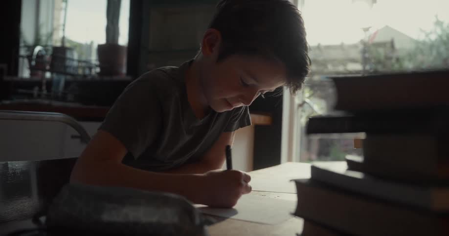 The vertical line of the window frame behind the boy a strong vertical line is formed by the edge of the window or door frame this line separates the dimly lit interior of the room from the bright overexposed light coming from the outdoors creating a