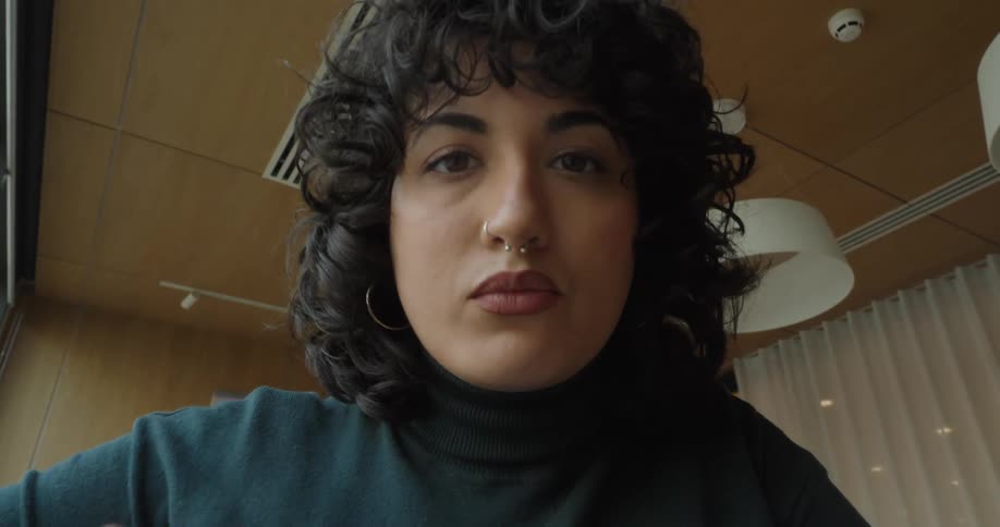The face of a young woman looking forward and clicking in the screen