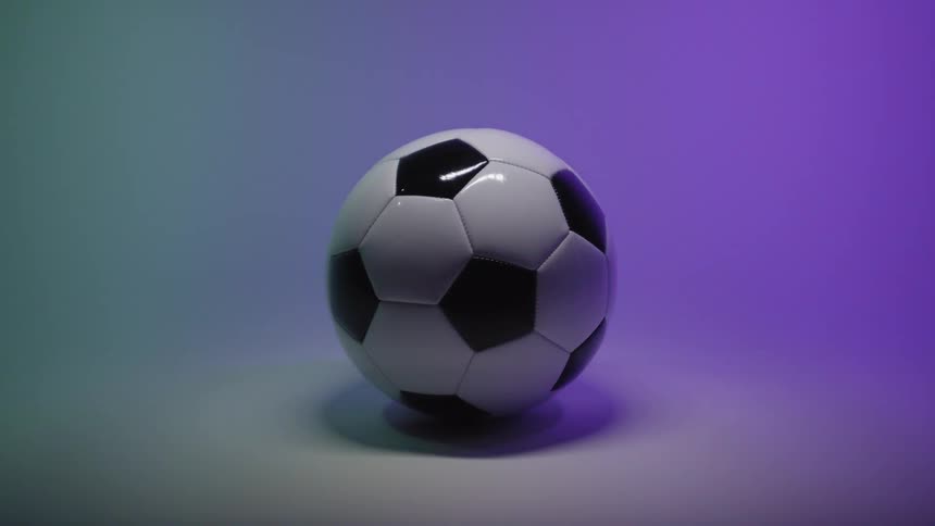 A soccer ball placed inside a room where the lighting shifts through different colors creating a soft glowing ambience around it