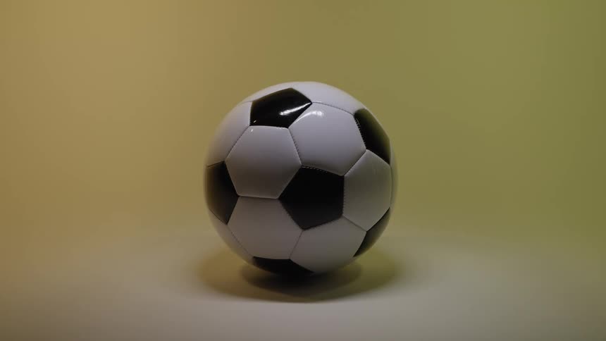 Soccer ball on the floor of a room with a yellow glow