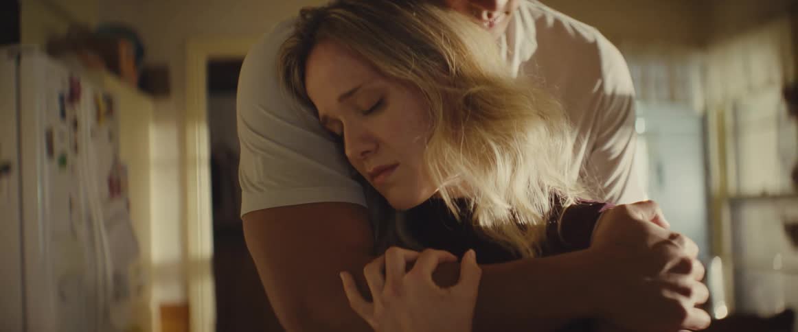 The woman being hugged is very sad