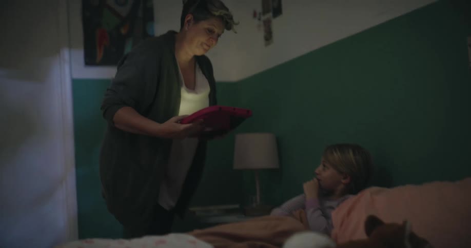 The mother takes her daughters tablet and puts her to bed