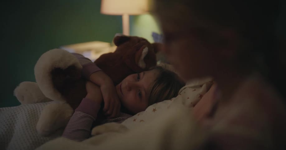 Two girls laying down in bed together