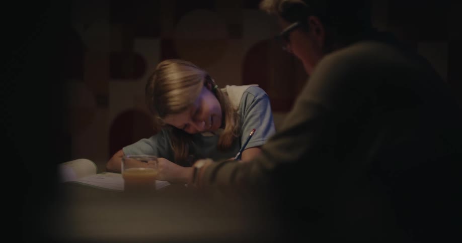 The girl is smiling as she does her homework