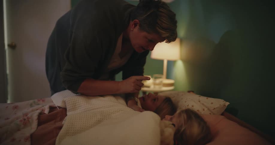 The mother talks to her children as she puts them to bed