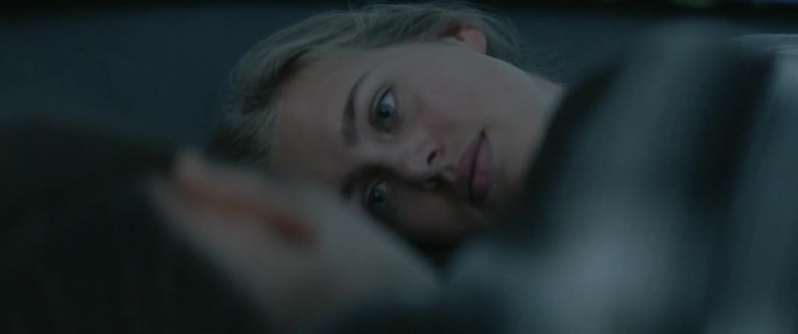 Two women laying next to each other in the dark