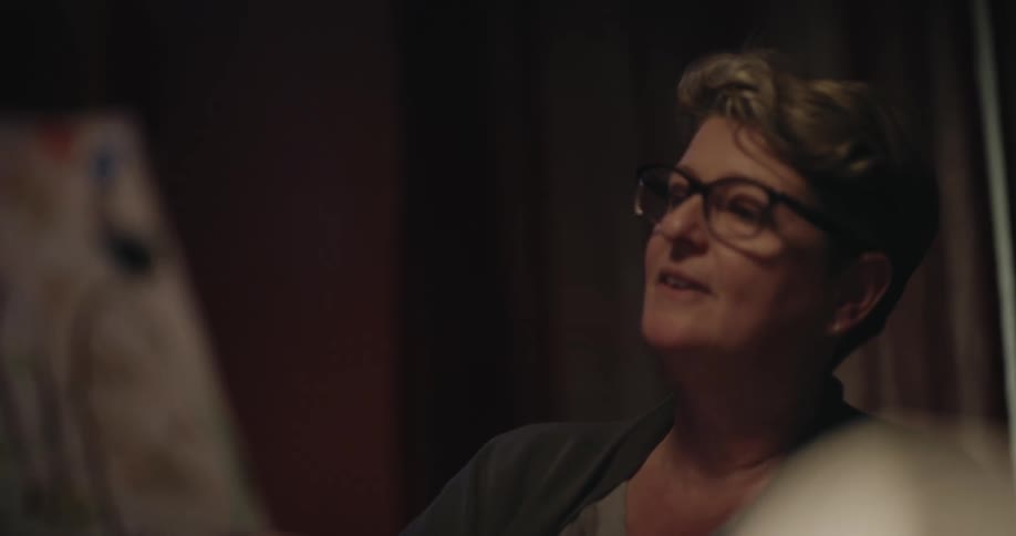 Woman with glasses viewing works of art