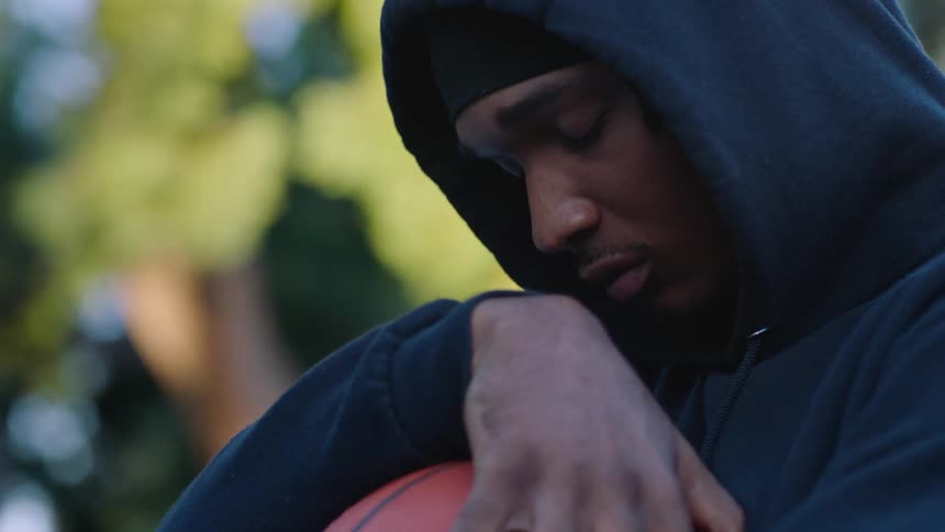 A man holding a basketball outdoors