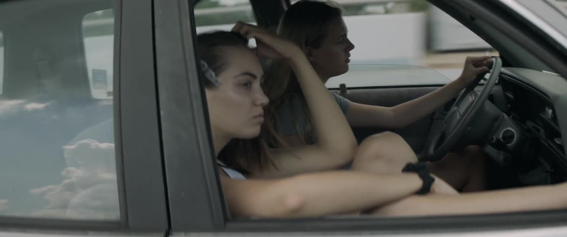 Two women traveling on road in car during the day