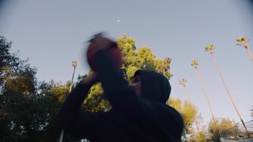 Young man throwing a basketball outdoors