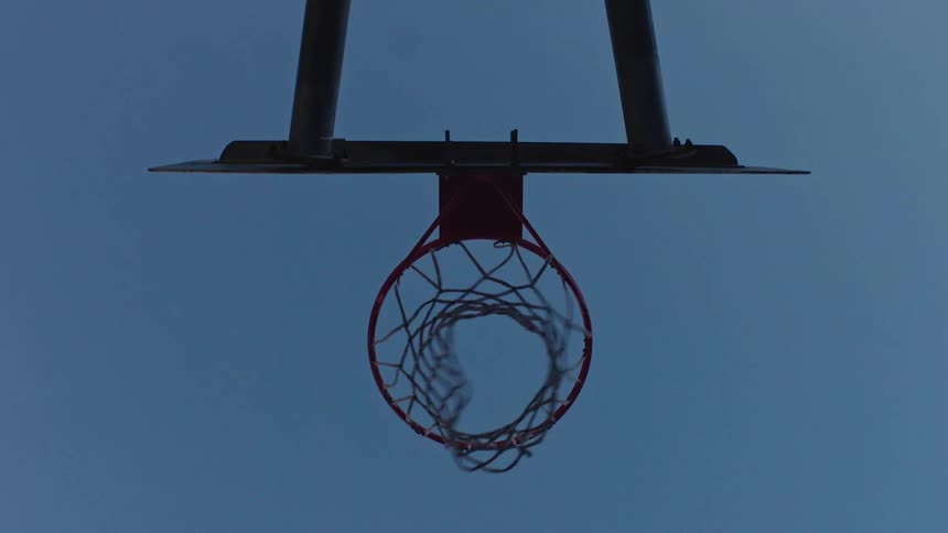 Basketball flies into the air and falls through the hoop and net