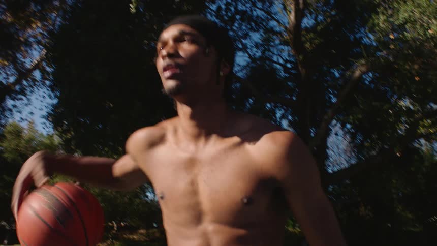 The man is moving back and forth while dribbling a basketball