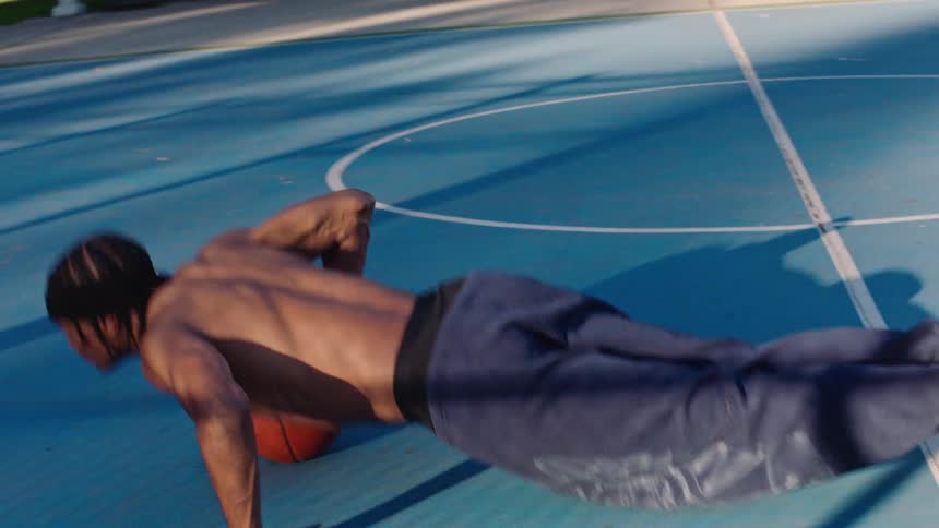 A man doing exercises on a basketball court