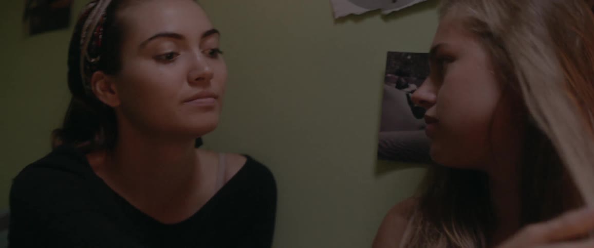 Two women talk in a bedroom